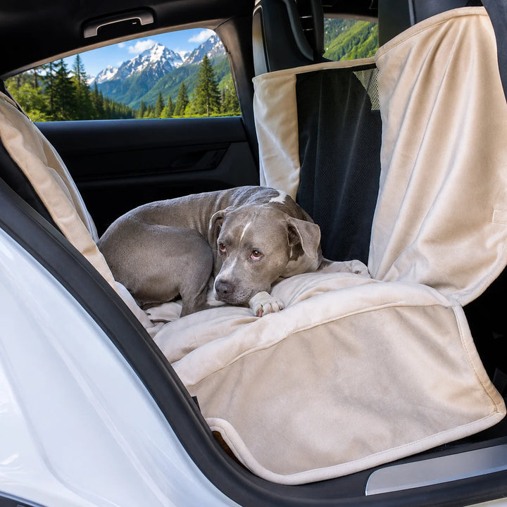 Animals Matter Companion Travel Hammock - Camel With Mesh dog car hammock in a luxury vehicle, featuring a gray dog on a plush camel rear-seat cover with mesh panel.