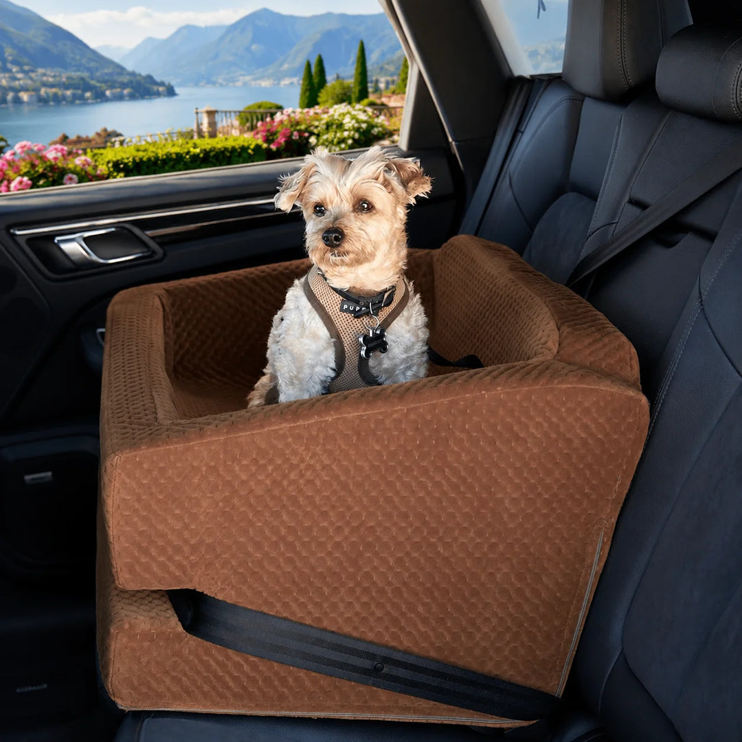 Animals Matter LA Dog Company Turbo Car Seat Limo dog car seat in saddle, featuring a small dog secured in a quilted seat inside a car with lake and mountain view.