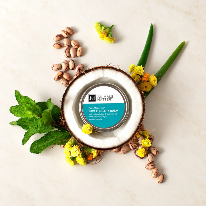 Animals Matter® Organic Vegan Paw Balm with the raw organic ingredients arranged around the balm